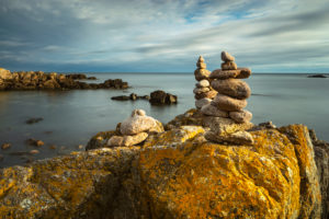 Denmark, Bornholm, Allinge-Sandvig, rocky coast with cairn in the morning light Denmark, Bornholm, Allinge-Sandvig, rocky coast with cairn in the morning light